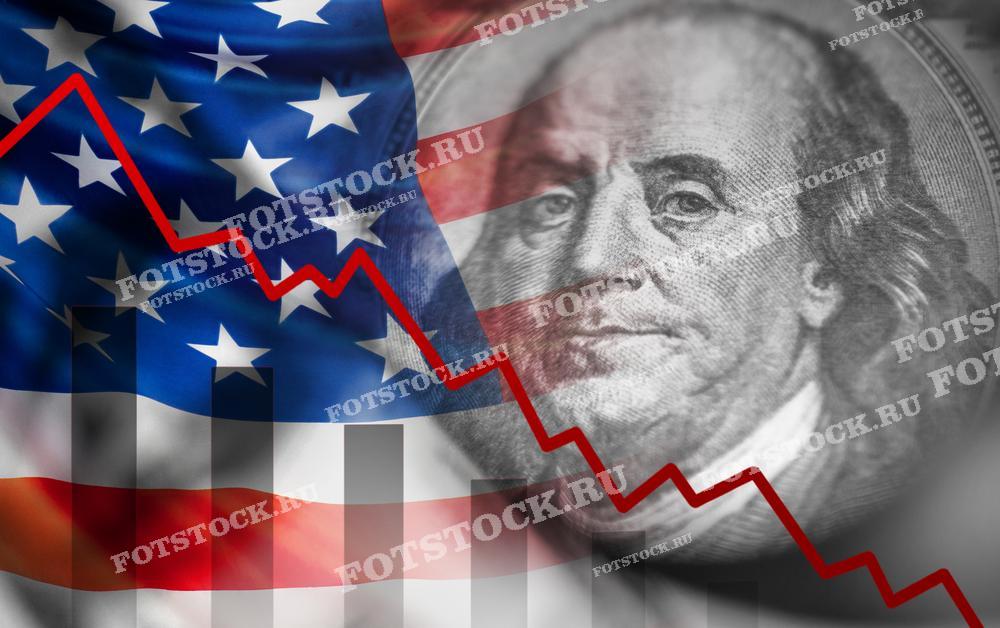 На фото изображен график экономического спада, наложенный на флаг США и портрет Бенджамина Франклина. Это символизирует ухудшение экономической ситуации в стране.